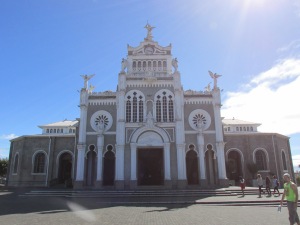 La Basílica de Nuestra Señora de los Ángeles reaches up to the heavens on a beautiful, sunny day.