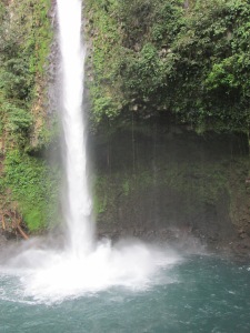 The La Fortuna Waterfall plummets down to its base, filling a small pool with cool, refreshing water.